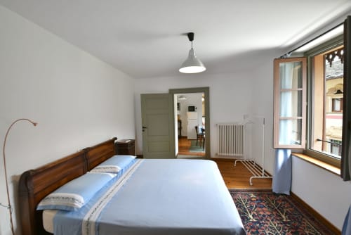 Ampia camera da letto nell'appartamento La Sorgente a Roseto del Drago, con letto in legno, pavimenti in parquet e vista sui monumenti