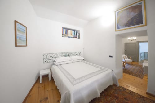 Camera luminosa nell'appartamento La Sorgente del B&B Roseto del Drago a Ponte in Valtellina, con letto bianco decorativo