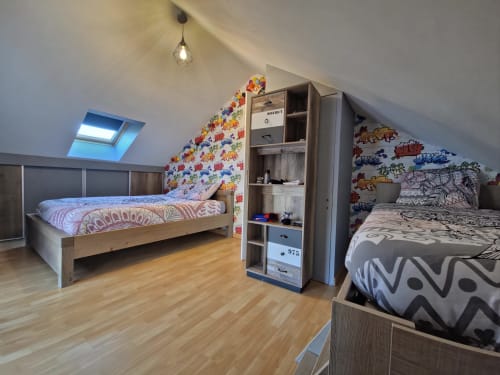 Chambre mansardée lumineuse aux Tanneries d'Ornans avec deux lits, décalcomanies colorées, parquet et fenêtre de toit