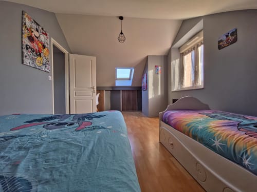 Spacieuse chambre twin à Les Tanneries B&B à Ornans avec literie colorée, parquets et lumière naturelle des velux