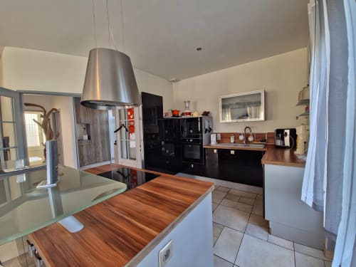 Cuisine moderne avec plan de travail en bois et suspension en acier inoxydable à l'appartement Les Tanneries, Ornans