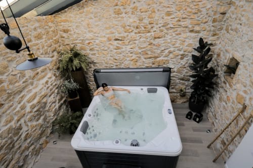 Hóspede relaxando na banheira de hidromassagem do spa de luxo Recantos D'Almerinda em Pombal, Portugal