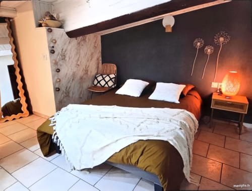 Cozy bedroom at Chez Mariebel' cottage in Ottonville with dark accent wall, white bedding, and warm orange lighting