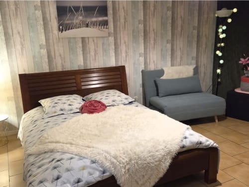 Cozy bedroom in Chez Mariebel's Gîte Mariebel cottage with wooden bed, seating area, and modern amenities in Ottonville