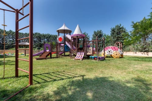 Colorido parque infantil con estructuras para escalar y toboganes en Domaine de la Bégude, Fayence