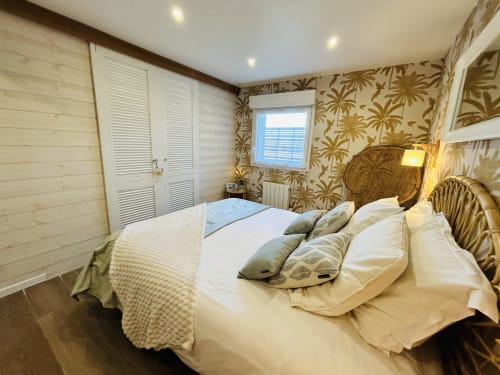 Chambre La Bounty à La Villa Plein Vent avec tête de lit en jonc, literie blanche, papier peint tropical et vue sur le jardin