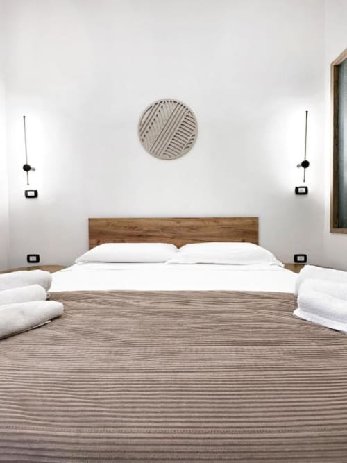 Camera da letto moderna presso I colori di Napoli B&B a Napoli con biancheria bianca, testata in legno e arte minimalista alle pareti