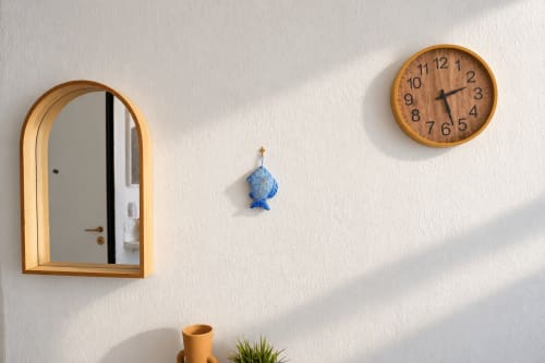 Arredamento costiero a Chiaia di Rose, Ischia: specchio in legno, orologio e ornamento pesce blu su parete bianca
