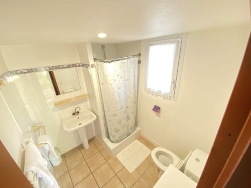Baño moderno en la casa rural Domaine de la Bégude con ducha, lavabo, inodoro y ventana