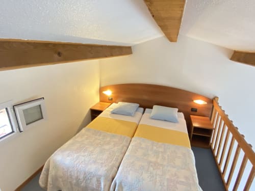 Acogedora habitación en Domaine de la Bégude Fayence con vigas de madera, cama doble, iluminación cálida y vistas al jardín