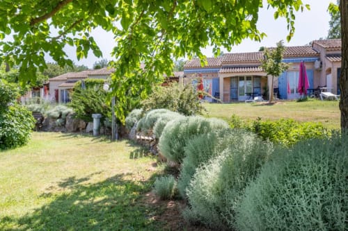 Gîte Domaine de la Bégude en Fayence con vistas al jardín, edificios de terracota y olivos