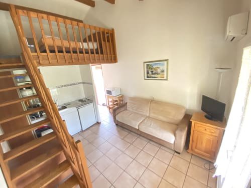 Cozy studio apartment at Domaine de la Bégude in Fayence with loft bed, kitchenette, sofa and TV