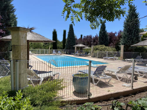 Piscina de resort en Domaine de la Bégude en Fayence con tumbonas, cipreses y cerca