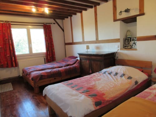 Chambre d'Angélique à La Ferme Buissonnière à Biol - chambre douillette aux poutres apparentes et lits jumeaux