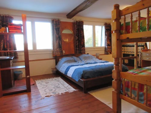 Chambre rustique à La Ferme Buissonnière avec poutres apparentes, lits à baldaquin et vue sur les montagnes à Biol, France