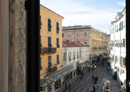 Vista dall'appartamento Toffee Matteotti di Seven Suites Sanremo con edifici italiani colorati e strada pedonale sottostante