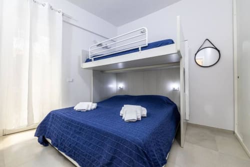 Camera moderna con letti a castello e biancheria blu presso SEVEN SUITES SANREMO, appartamento hotel a Sanremo