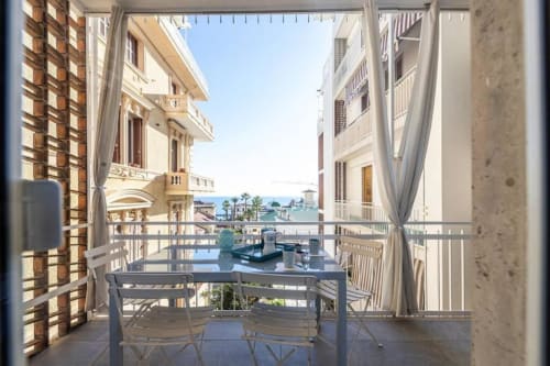 Balcone con tavolo da pranzo con vista sul mare e la costa di Sanremo, appartamento Seven Suites con vista sulla città