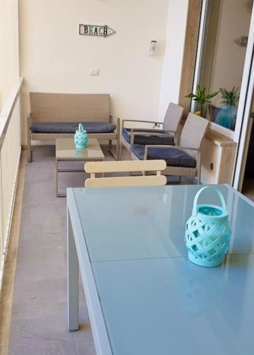 Zona living dell'appartamento a Sanremo con tavolo da pranzo, divano e balcone affacciato sul mare