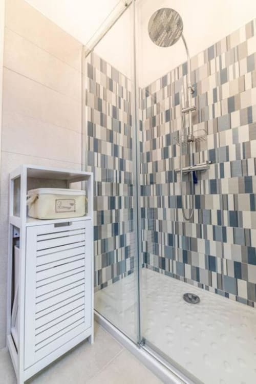 Bagno moderno nell'appartamento SEVEN SUITES SANREMO Toffee Casinò con piastrelle a scacchi e doccia a filo pavimento