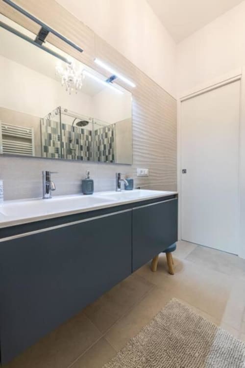Bagno moderno con doppio lavabo, armadiatura scura e piastrelle rigate presso SEVEN SUITES SANREMO, Toffee Casinò