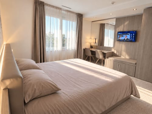 Chambre lumineuse et moderne aux Résidences Attica à St-Sulpice avec vue sur le lac, bureau, TV et mobilier contemporain