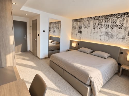 Chambre studio contemporaine aux Résidences Attica St-Sulpice avec lit queen, vue sur le lac et décoration moderne