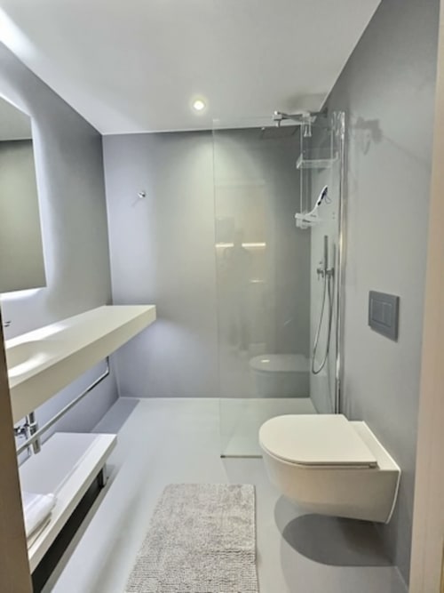 Salle de bain moderne aux Résidences Attica à St-Sulpice avec douche à l'italienne, sanitaires blancs et design contemporain