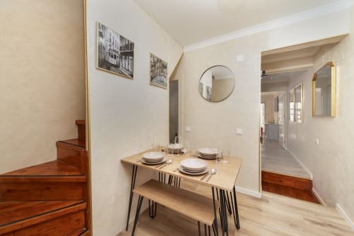 Dining area in Bica Mini Hostel apartment, Lisboa with wooden table, place settings, and mirror