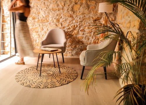 Sala de pedra rústica no Recantos D'Almerinda Pombal com cadeiras modernas, tapete redondo estampado e plantas em vasos