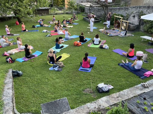 Outdoor yoga class on green lawn at Roseto del Drago in Ponte In Valtellina, Italy