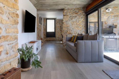 Sala de estar rústica moderna em Recantos D'Almerinda com paredes de pedra, sofá cinzento e acesso ao terraço em Pombal