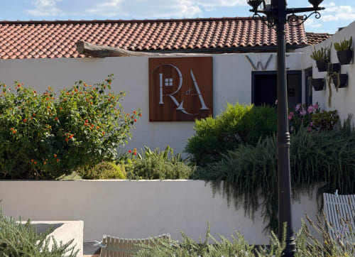 Entrada do hotel Recantos D'Almerinda em Pombal com sinalização rústica em madeira, paredes brancas, telhado em terracota e ambiente mediterrânico