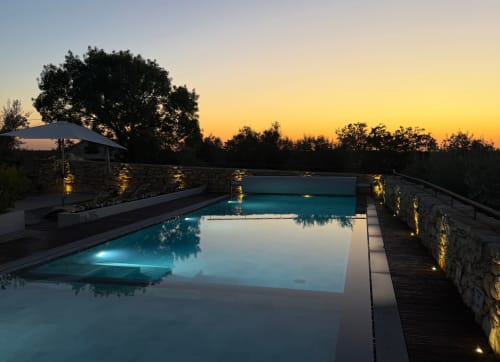Piscina de luxo em Recantos D'Almerinda em Pombal ao anoitecer com muros de pedra iluminados e árvores