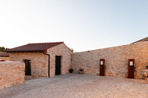 Pátio em pedra no Recantos D'Almerinda com edifícios de telhado em barro tradicional em Pombal, Portugal