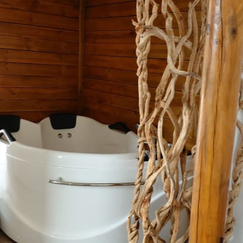 Intérieur rustique en bois avec baignoire blanche et détails en corde aux Loyes B&B, Jaillans