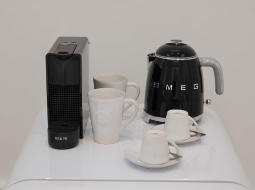 Chaleira SMEG, cafeteira Krups e canecas brancas sobre superfície branca no Oporto Comfort Charming Cedofeita Porto