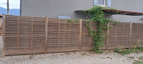 Clôture à lames de bois avec lierre grimpant du gîte Les Loyes à Jaillans, France