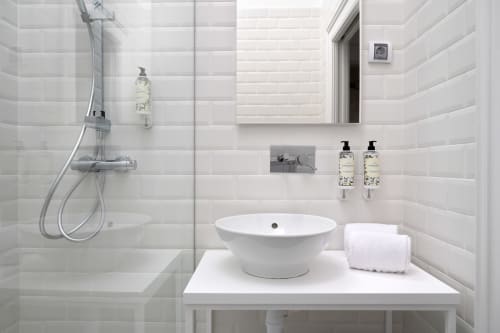 Casa de banho moderna no Oporto Comfort Charming Cedofeita com azulejos brancos, lavatório, chuveiro e comodidades no Porto