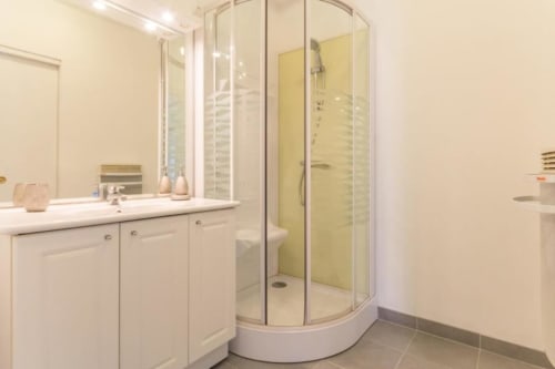 Salle de bains moderne avec vasque, miroir et douche à paroi courbe à la chambre Le Cygne du Moulin De La Côte, Saint Vigor
