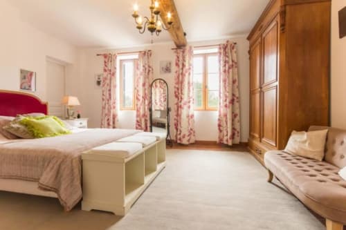 Élégante chambre L'Orchidée au Moulin De La Côte, Saint Vigor avec rideaux fleuris, tête de lit rose et vue sur le jardin