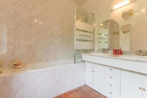 Salle de bains en marbre avec vasque, grands miroirs et douche à l'italienne au Moulin De La Côte
