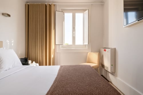 Quarto moderno no Oporto Comfort Charming com cama de casal, janelas com vista para a cidade e mobiliário contemporâneo no Porto