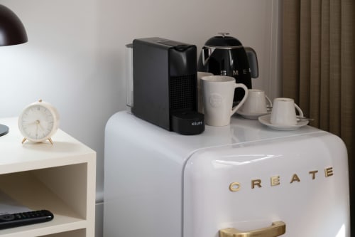 Estação de café moderna com chaleira SMEG, máquina Krups e canecas brancas no hotel Oporto Comfort Charming