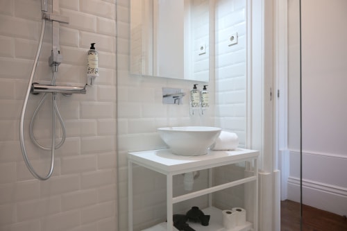 Banheiro moderno do Oporto Comfort Charming Cedofeita com cuba de apoio, chuveiro walk-in e acabamentos em azulejo branco