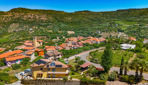 Vista aerea della villa Sardegna Explora House a Modolo con tetti in cotto immersi nelle verdi colline toscane