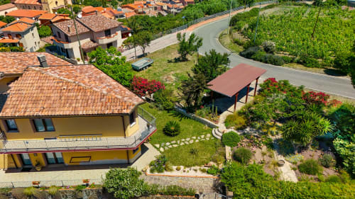 Vista aerea della villa Sardegna Explora House a Modolo con tetti in cotto, giardini paesaggistici e strade di campagna
