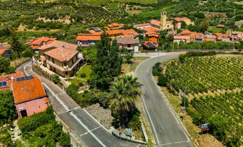 Vista aerea della villa Il Castello di Modolo con tetti in coppi arancioni, vigneti e campagna della Sardegna, Italia