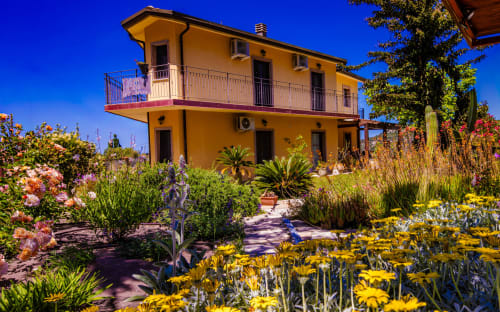 Villa gialla con terrazza circondata da fiori colorati a Modolo, Sardegna Explora House - IL CASTELLO DI MODOLO