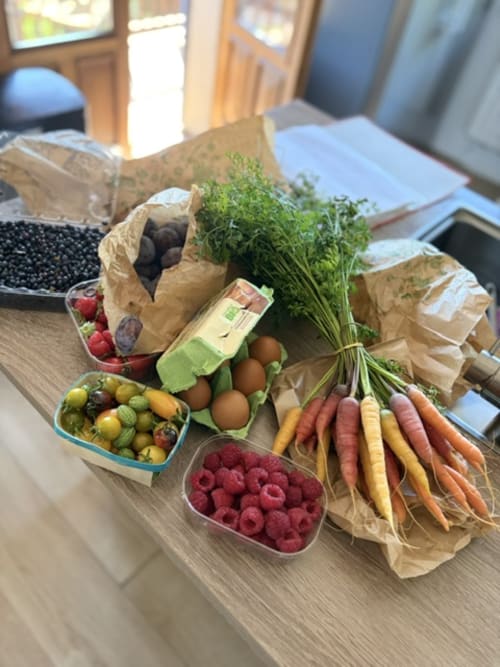 Fresh local produce display at La Maison Du Chevalier B&B in Marat, France including berries, carrots, eggs and herbs
